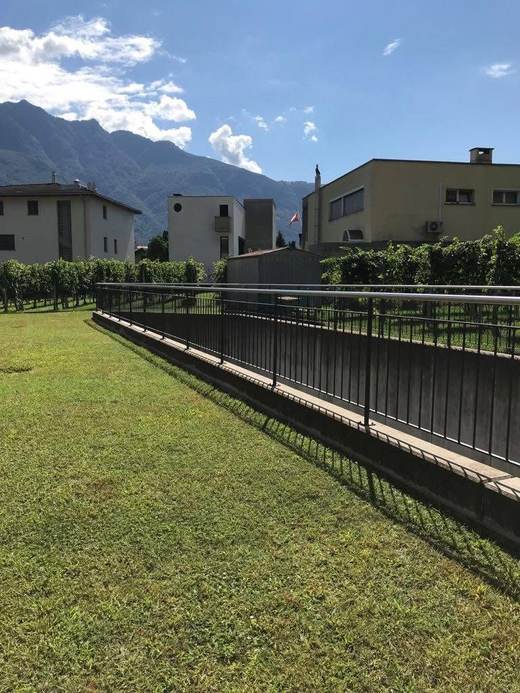 Ringhiera in ferro con corrimano in acciaio inox lungo una passerella esterna